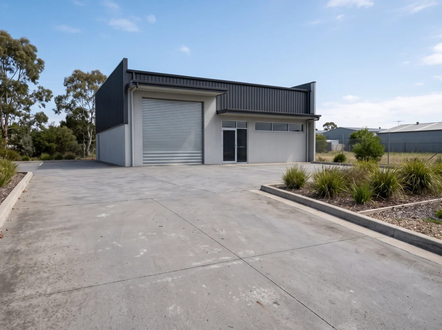 Concrete driveway and hardstand outside a modern Australian light-commercial building