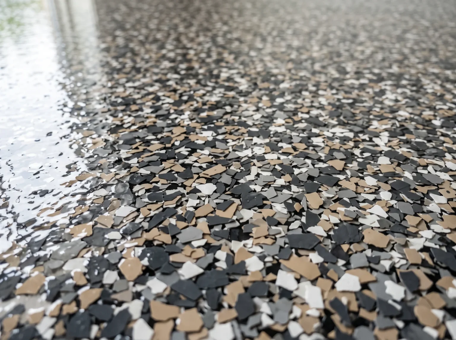 Decorative epoxy flake finish in a charcoal, grey and tan blend under a gloss clear resin coat