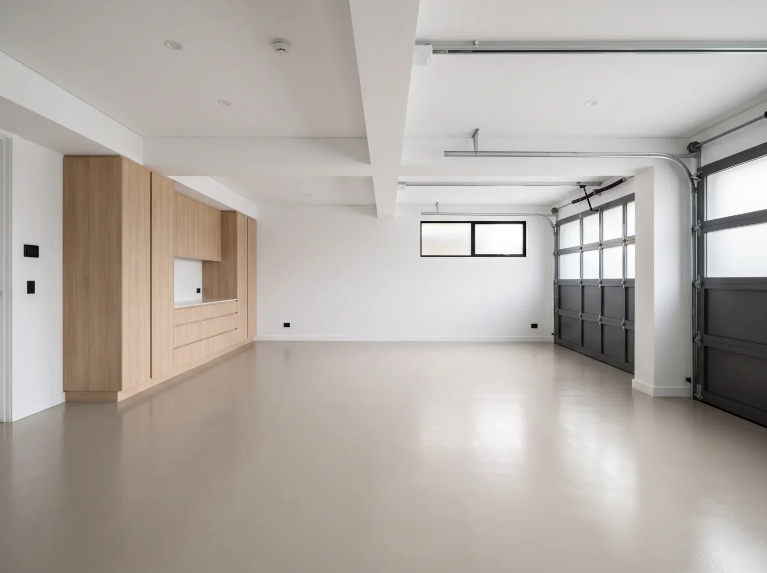 Bright premium double garage with a pale sand-grey solid colour coated floor and built-in storage